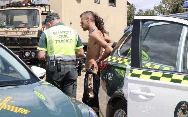 Un agente de la Guardia Civil habla con uno de los asistentes a la fiesta ilegal a orillas del embalse zamorano de Almendra. Un agente de la Guardia Civil habla con uno de los asistentes a la fiesta ilegal a orillas del embalse zamorano de Almendra.