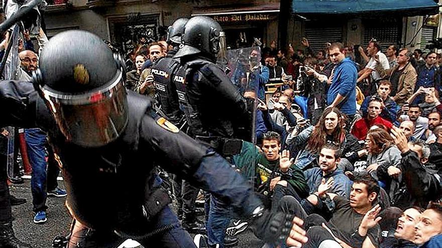 Agentes policiales cargan contra ciudadanos que defendían la jornada del referéndum. | FOTO: EFE