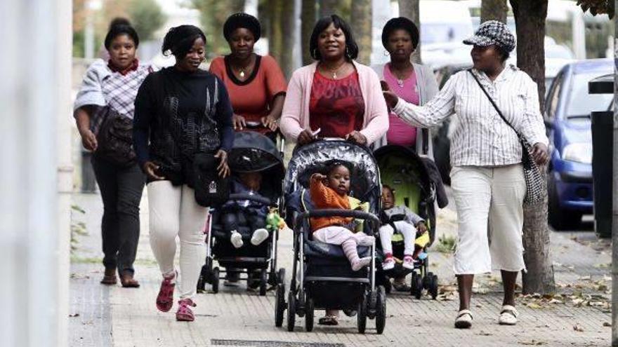 Un grupo de mujeres inmigrantes paseando junto a sus hijos.