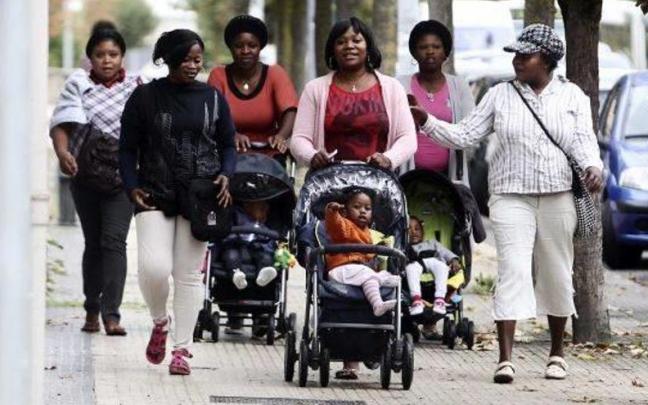 Un grupo de mujeres inmigrantes paseando junto a sus hijos.