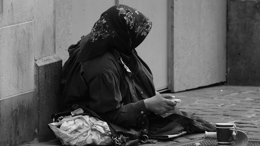 Una mujer pidiendo limosna en la calle.