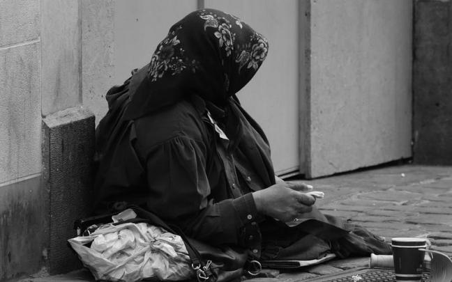 Una mujer pidiendo limosna en la calle.