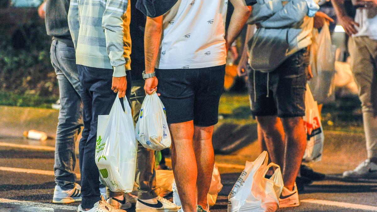 Un grupo de jóvenes con botellas de alcohol en bolsas. Foto: J. M. Martínez