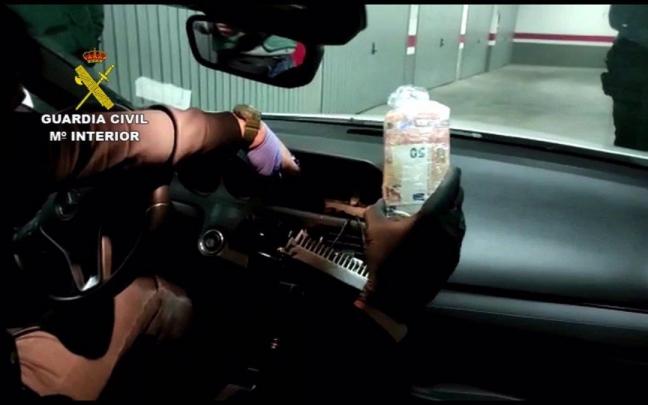 Una agente inspecciona uno de los falsos veh&iacute;culos comerciales que utilizaba la organizaci&oacute;n criminal para transportar la droga.