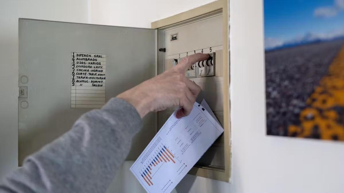 Un hombre con una factura de la luz en la mano manipula una cuadro eléctrico ¡¡