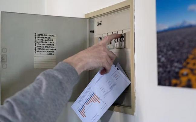 Un hombre con una factura de la luz en la mano manipula una cuadro eléctrico ¡¡ Un hombre con una factura de la luz en la mano manipula una cuadro eléctrico ¡¡