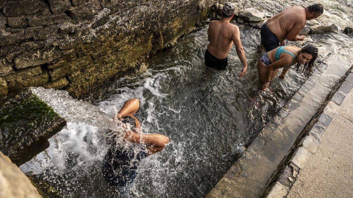 Bañistas refrescándose en el "lavadero" de Ibero este fin de semana.