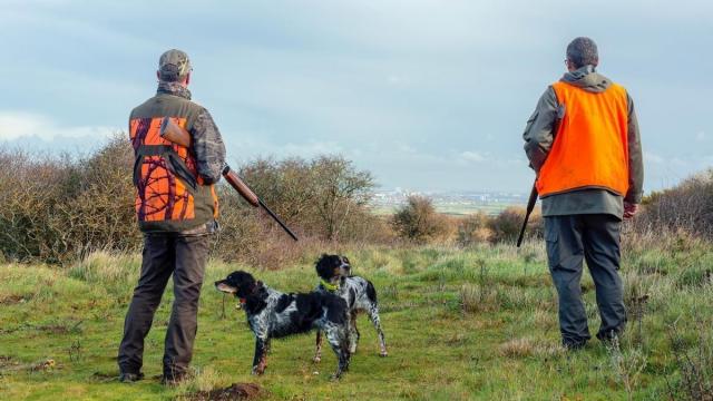 Dos cazadores junto a sus perros en una imagen de archivo.