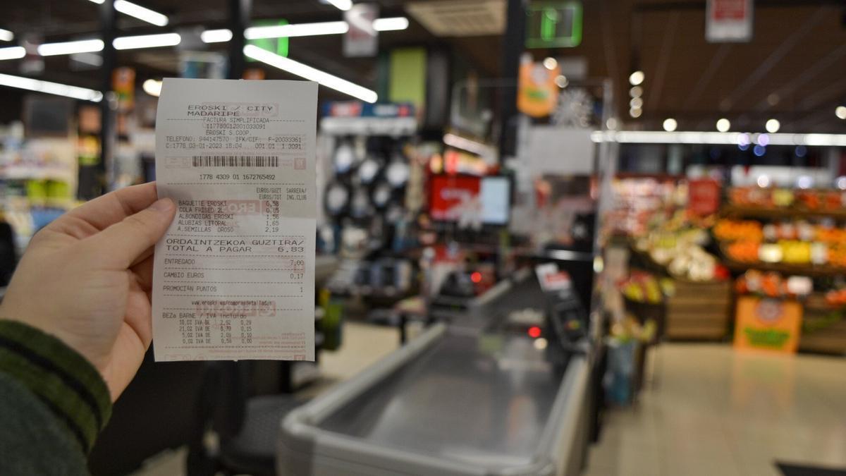 Una consumidora revisando su factura, ayer, en un supermercado de la cadena Eroski.