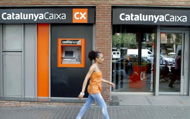 Una mujer pasa frente a una sucursa bancaria.