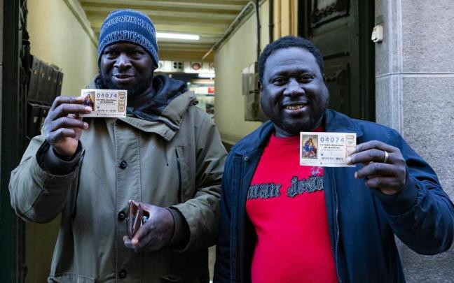 Ibrahim Kante (d) muestra, junto a un amigo, el décimo premiado. Ibrahim Kante (d) muestra, junto a un amigo, el décimo premiado.