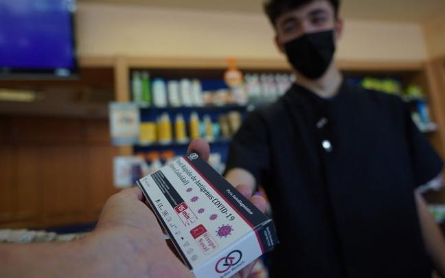 Un joven compra un test de ant&iacute;genos