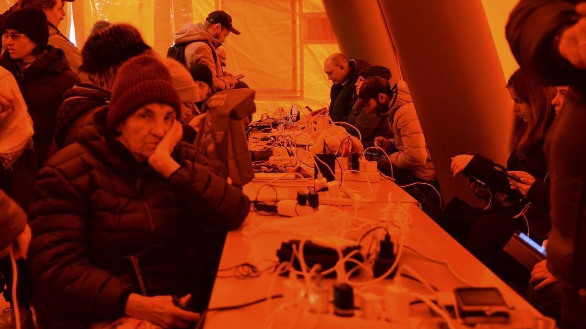 Ciudadanos de Jersón cargan sus teléfonos móviles en una tienda
