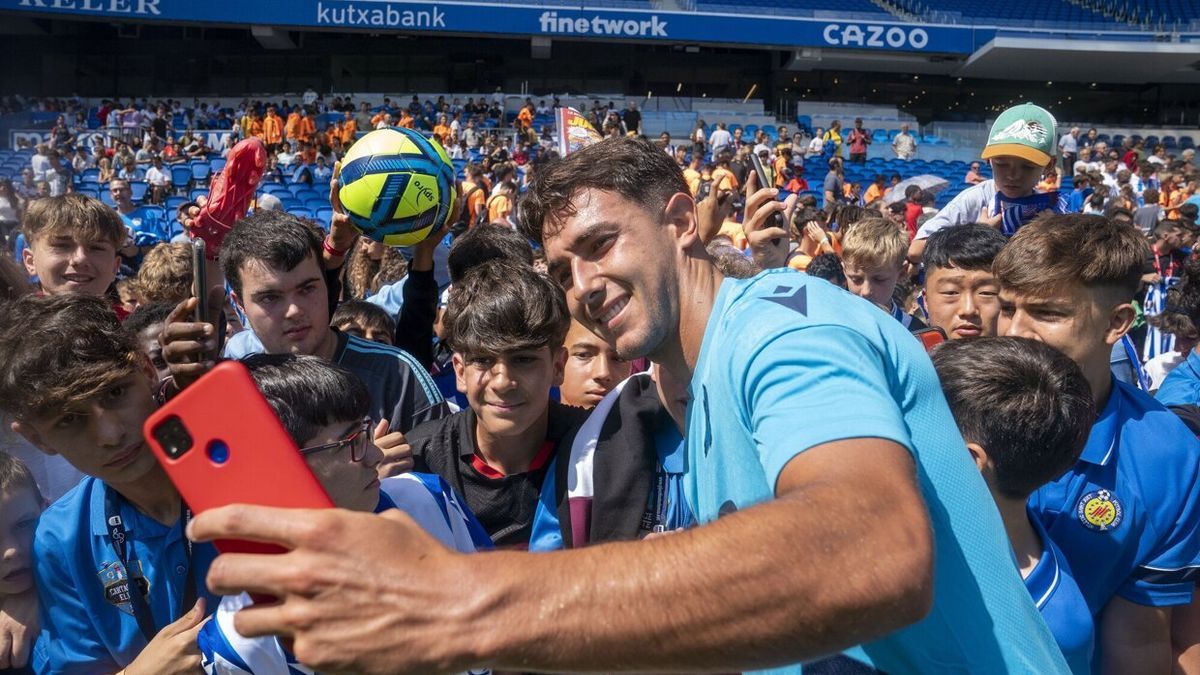 Zubimendi se saca una foto con varios aficionados en un entrenamiento en Anoeta.