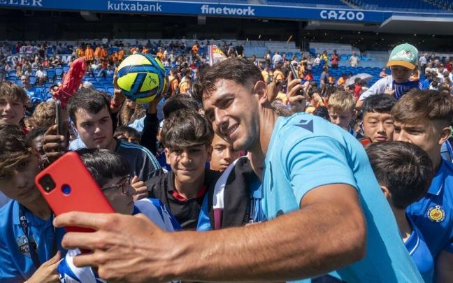Zubimendi se saca una foto con varios aficionados en un entrenamiento en Anoeta.
