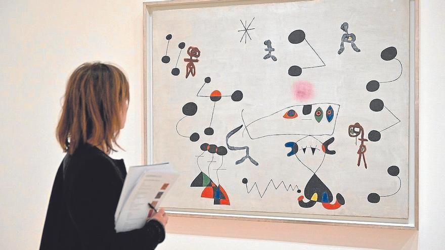 Una mujer observa uno de los cuadros de Miró en la exposición.