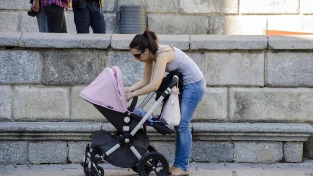 Una joven paseando a su beb&eacute;.