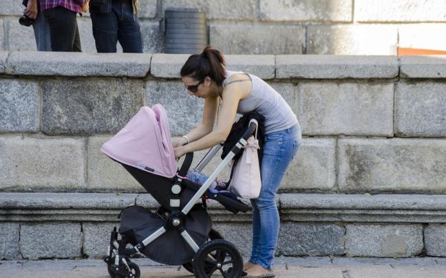 Una joven paseando a su bebé.
