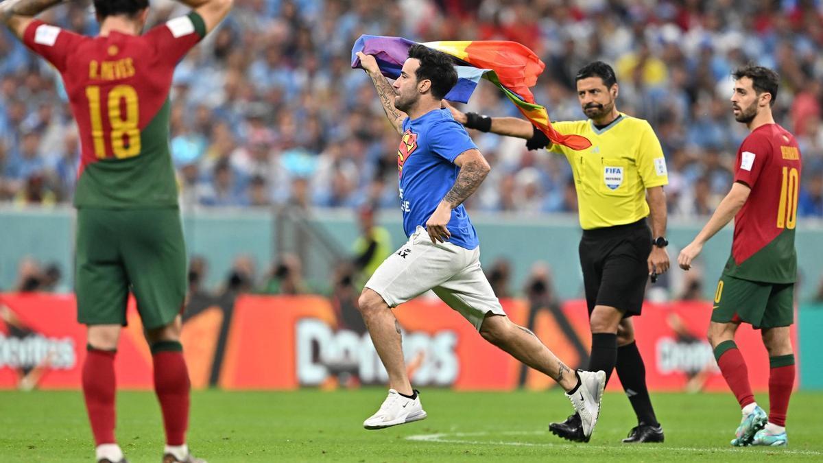 Un aficionado salta al césped con una bandera arcoíris durante el Portugal-Uruguay imagen