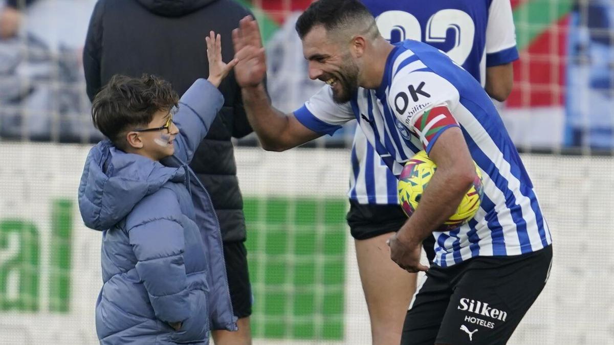 Luis Rioja charla con un niño sobre el césped de Mendizorroza al término del partido ante el Ibiza