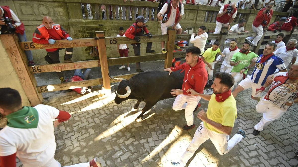 Ivan Benítez, tumbado en el suelo, continúa tomando fotografías del encierro.