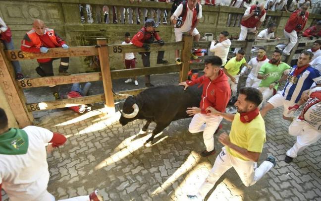 Ivan Ben&iacute;tez, tumbado en el suelo, contin&uacute;a tomando fotograf&iacute;as del encierro.