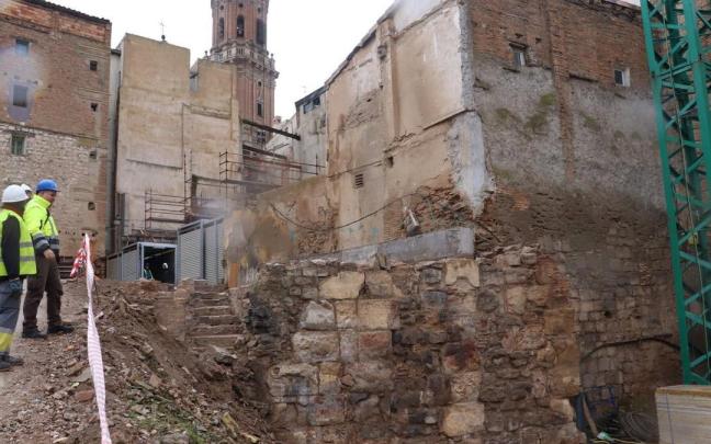 Los arqueólogos observan el muro islámico, en primer término, y detrás las escaleras del sótano, al fondo la torre de la catedral.