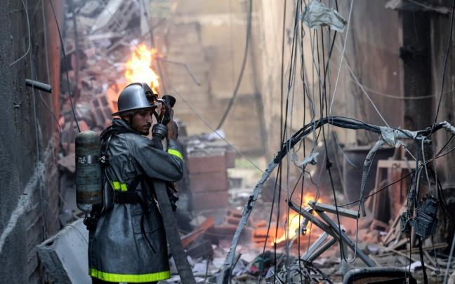 Un bombero apaga un fuego provocado por un ataque israel&iacute; en Gaza.