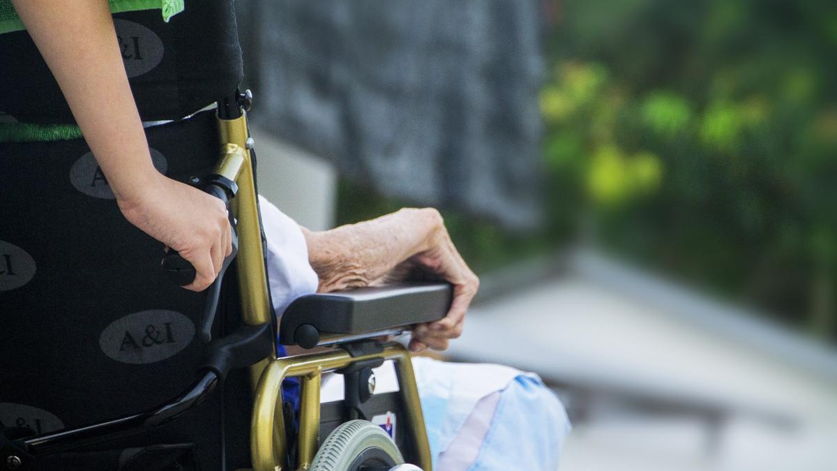 Una enfermera cuida de una persona anciana.