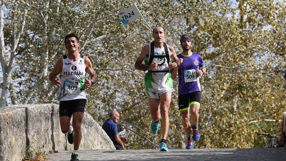 Tres corredores atravesando el puente de la Magdalena
