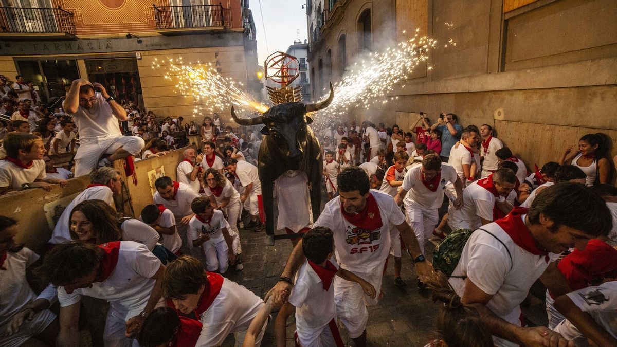 Niños corriendo delante del toro de fuego en San Fermín.