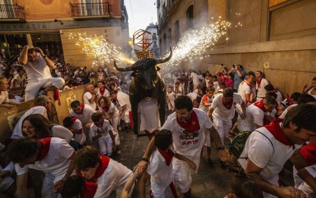 Niños corriendo delante del toro de fuego en San Fermín.
