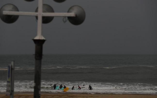 Unos deportistas practican surf en la playa de la Zurriola este jueves Unos deportistas practican surf en la playa de la Zurriola este jueves