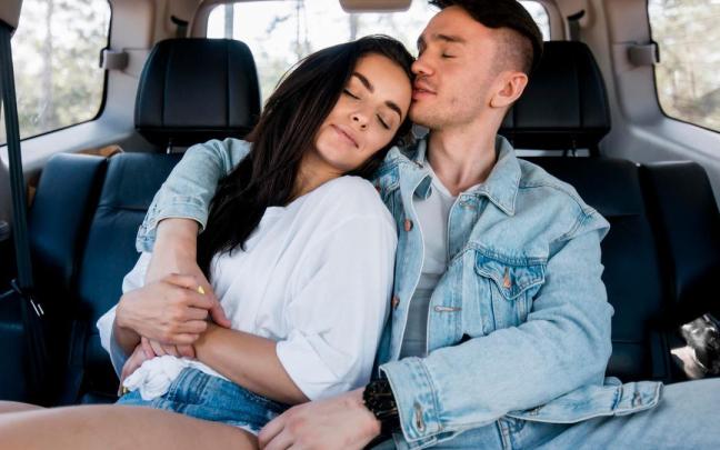 Una pareja, abrazada en el interior de su coche.