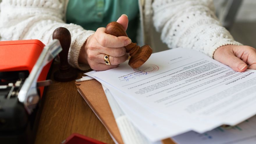 Una mujer sella su propio testamento.