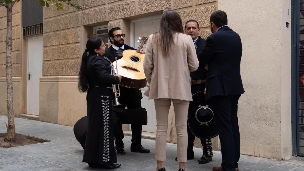 Un grupo de tres mariachis habla con la responsable de comunicación en la sede de Junts.