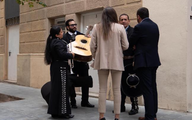 Un grupo de tres mariachis habla con la responsable de comunicación en la sede de Junts.