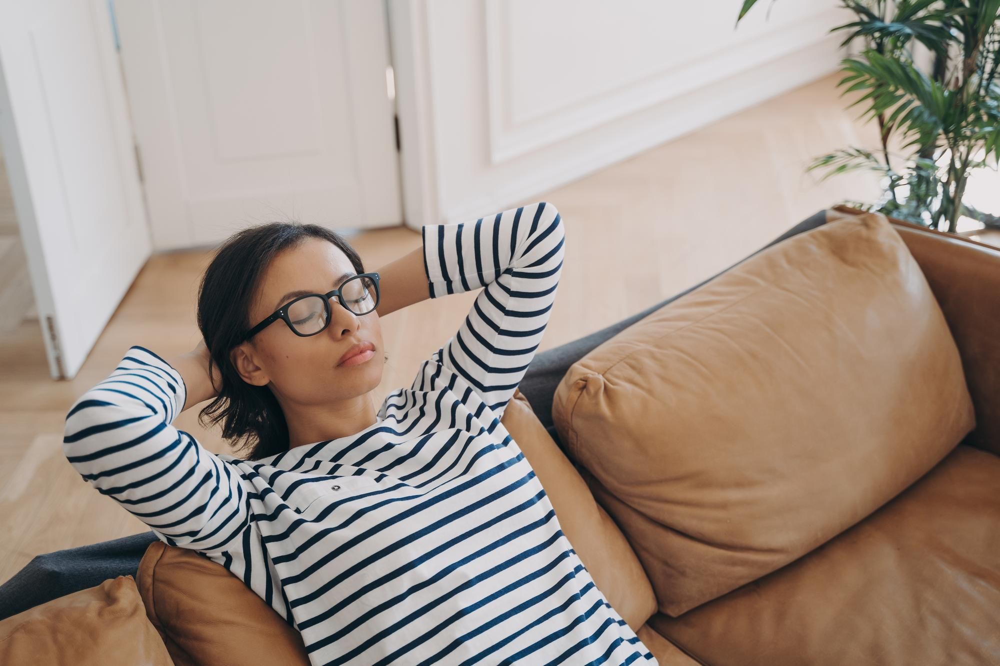 Una mujer duerme una pequeña siesta en el sofá.