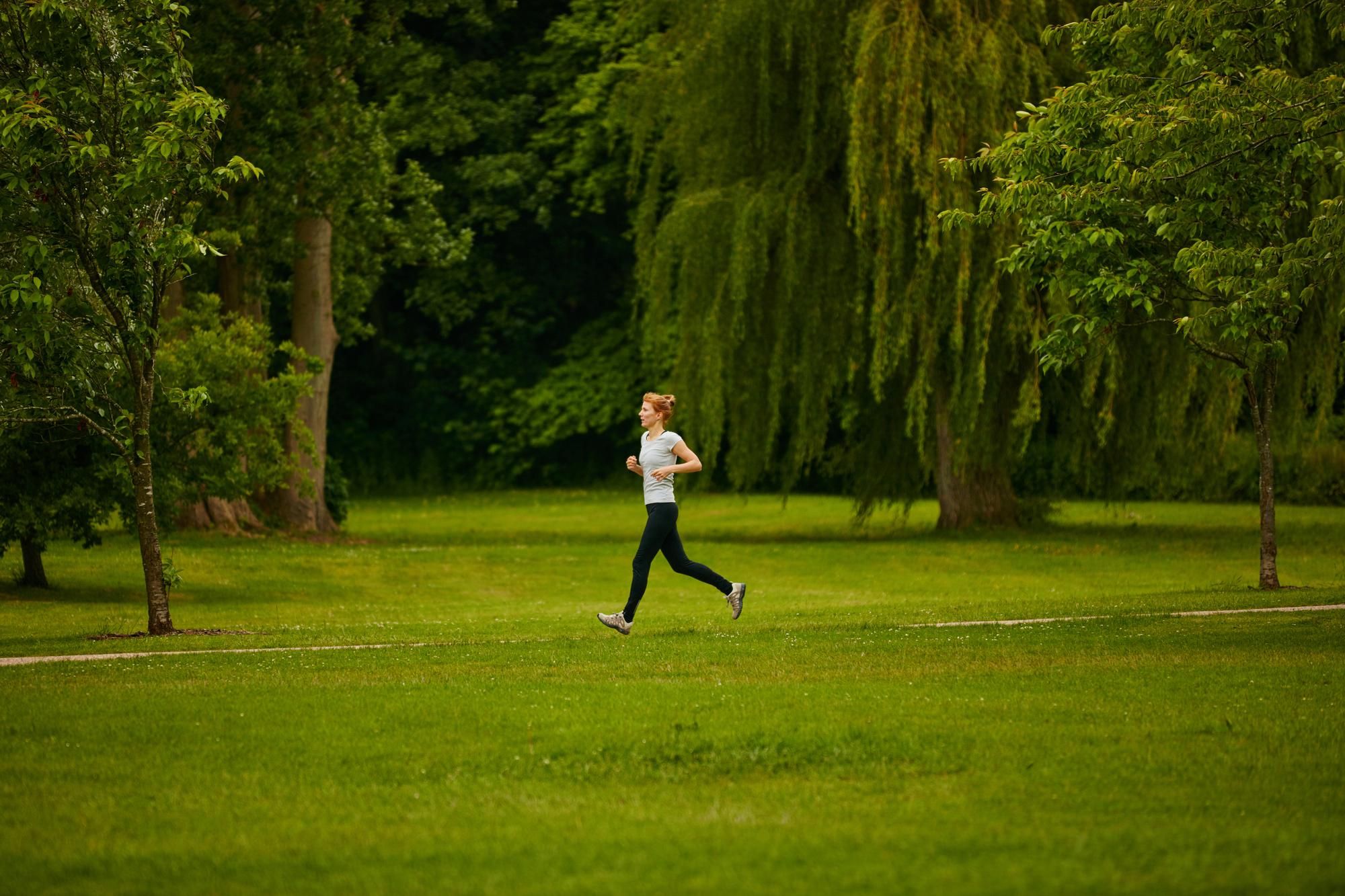 Una mujer practica deporte en un parque.