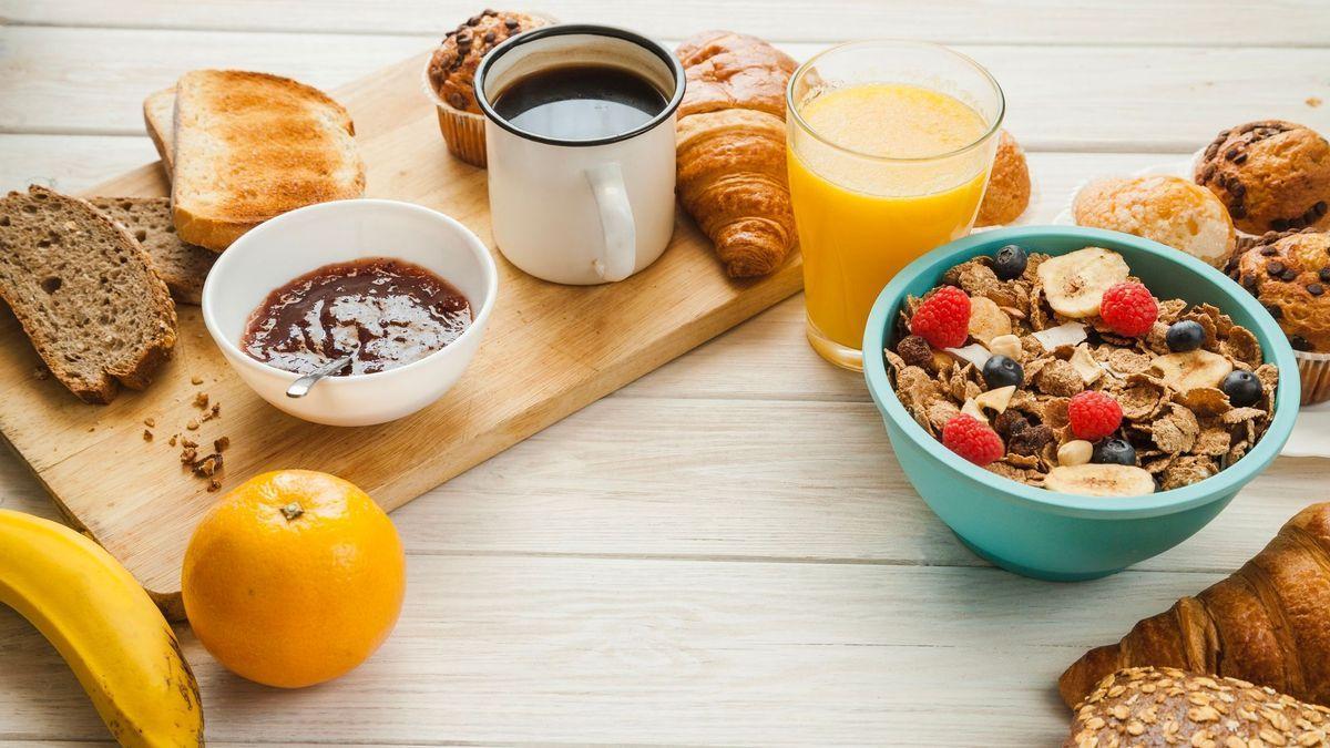 Café, bollería, fruta, pan y cereales listos para ser degustados en el desayuno.