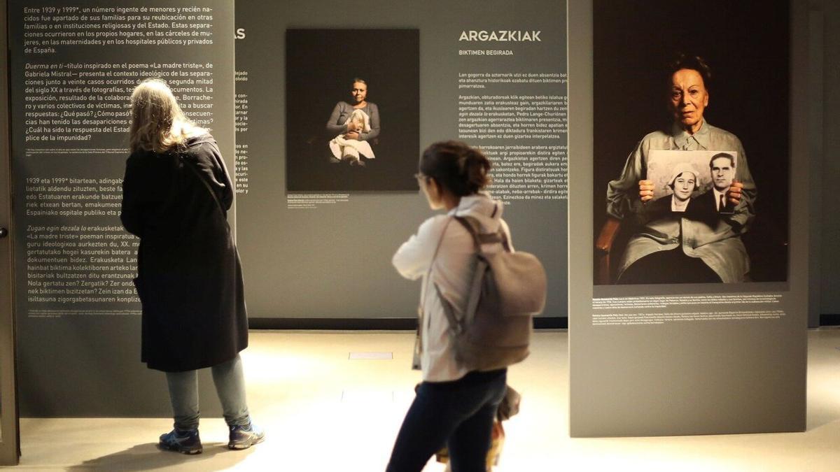 Varias personas contemplan la exposición ‘Duerma en ti... Maternidades robadas’ en el Planetario de Pamplona.