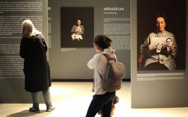 Varias personas contemplan la exposición ‘Duerma en ti... Maternidades robadas’ en el Planetario de Pamplona.