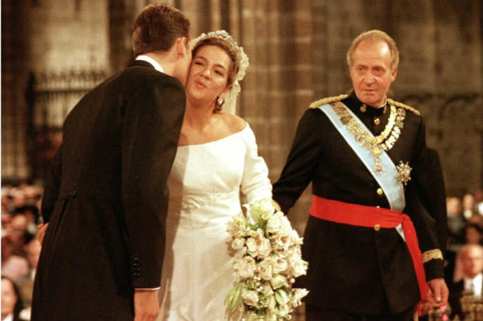 Juan Carlos de Borbón observa el beso de su hija la infanta Cristina con Iñaki Urdangarin en el día de su boda.