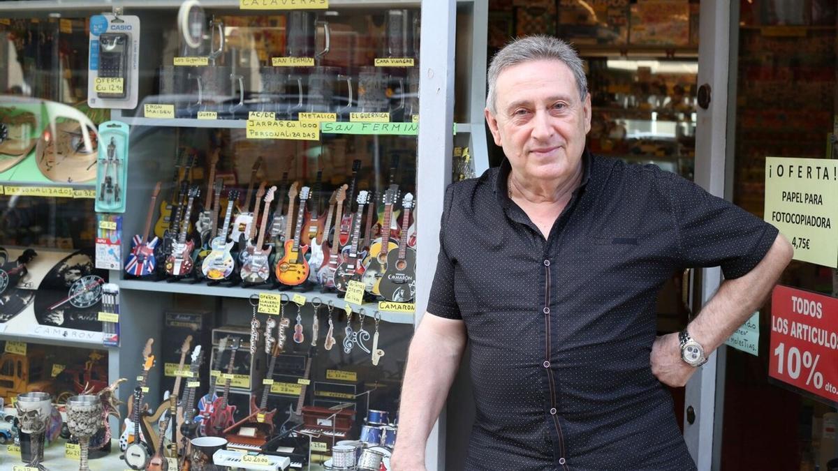 Juan Goñi Larrea posa en el escaparate de su librería, repleto de guitarras.