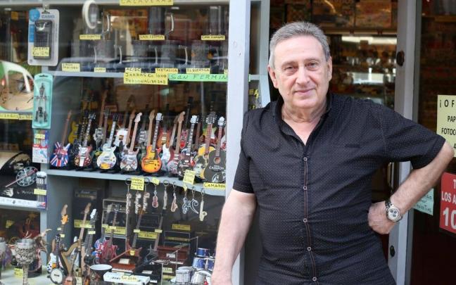 Juan Goñi Larrea posa en el escaparate de su librería, repleto de guitarras.