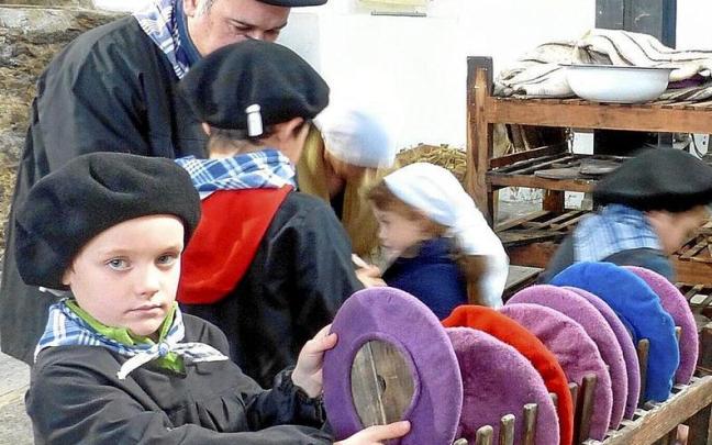 Un niño observa txapelas de diferentes colores. Un niño observa txapelas de diferentes colores.