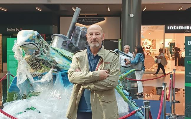 Jesús Susilla posa junto a la escultura que ha creado con materiales reciclados y que preside el hall central del centro comercial Max Center.