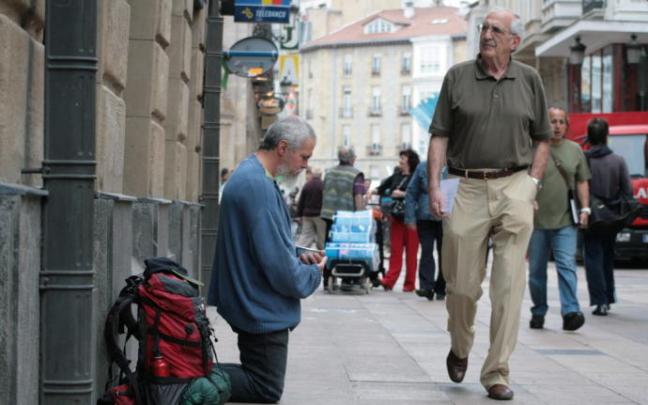 Una persona pide dinero en una calle céntrica de la ciudad.