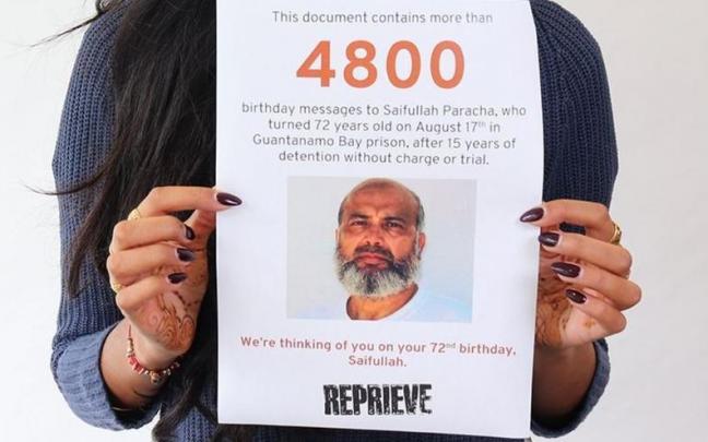 Una mujer muestra un cartel con la imagen de Saifulá Paracha.