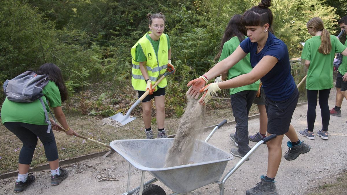 Jóvenes del campamento acondicionan el sendero de Morterutxo, adaptado a personas invidentes.